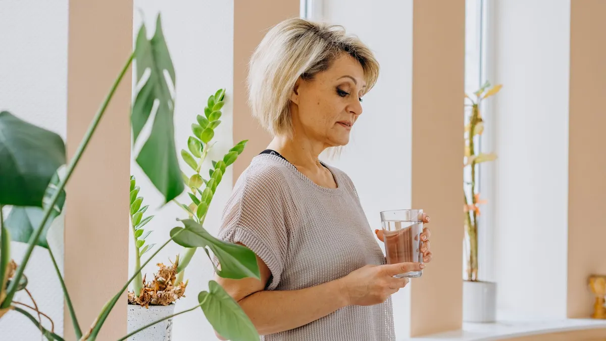 Older adult taking an alpha-lipoic acid supplement in the morning